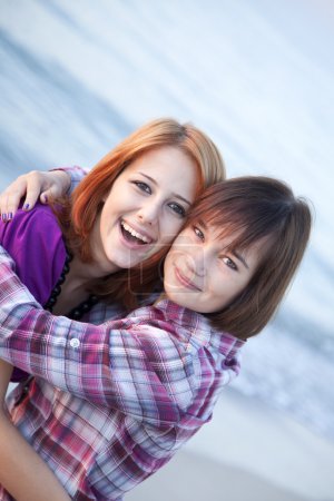 Closeup portrait of two happy girls on the beach