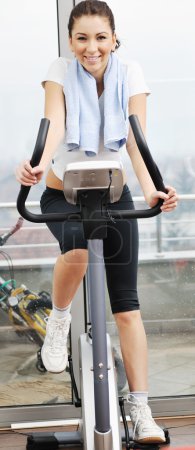 Womanworkout in fitness club on running track machine