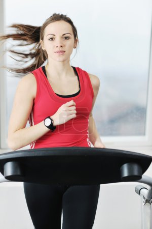 Womanworkout in fitness club on running track machine