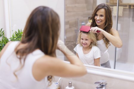 Mother brushes daughter's hair