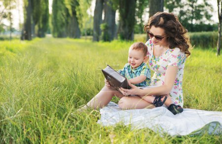 Mother with curly hairstyle reading fairy tales for baby