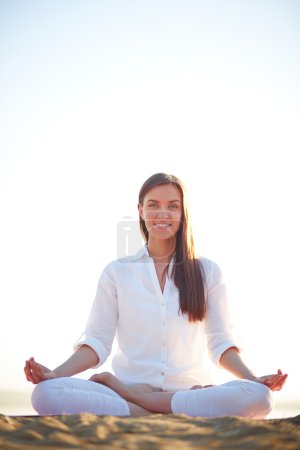 Woman sitting in pose of lotus