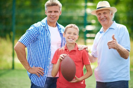 Boy with rugby ball, grandfather and father