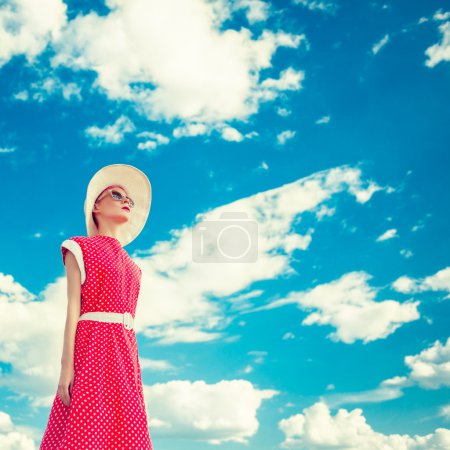 Portrait of retro girl on the blue sky background
