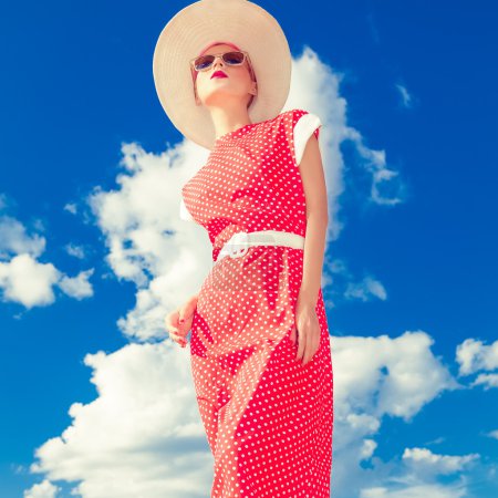 Fashion retro girl on the blue sky background