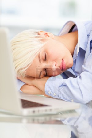 Exhausted businesswoman sleeps on notebook