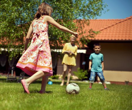 Happy family playing football in the garden