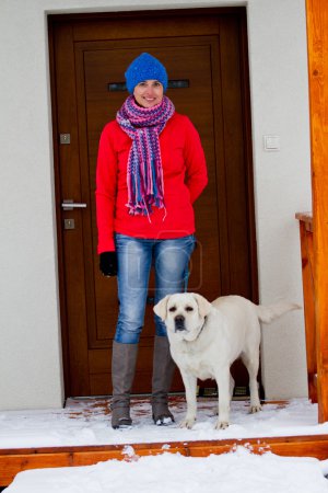Winter walk with dog - Portrait of woman with dog in front of the house