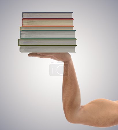 Stack of books in the hands a strong man