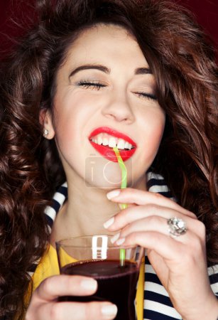 Beautiful brunette woman drinking cocktail on a party