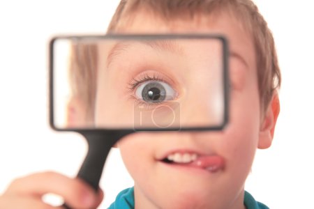 Boy looks through magnifier with interest