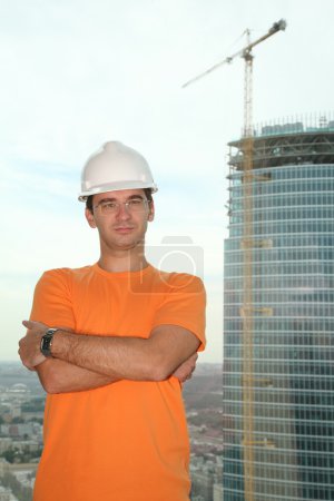 Worker in the helmet on the building
