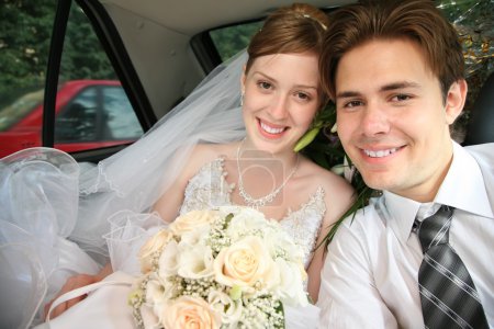 Fiance and bride sit in the automobile