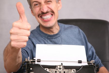Man after the typewriter shows gesture by the finger
