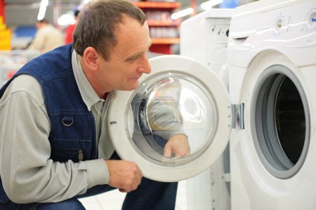 Man looks at washing machine in store