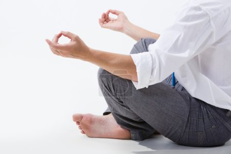 Photo of relaxed businessman meditating over white background