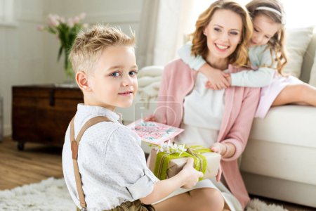 Boy presenting gift to mother