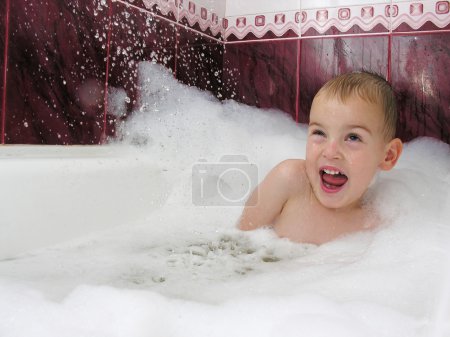 Boy in bath hides from streem of water