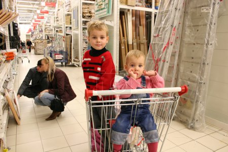Children in shopingcart and couple