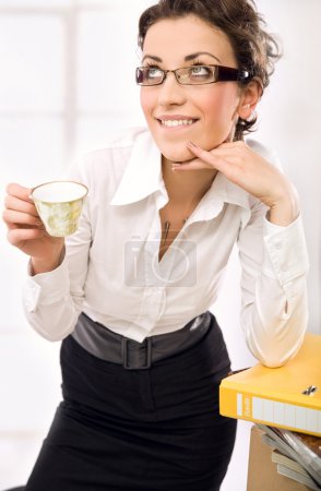 Attractive secretary drinking coffee