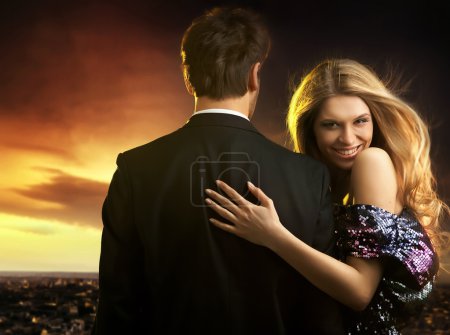 Conceptual portrait of a young couple in elegant evening dresses