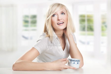 Cheerful young woman drinking coffee