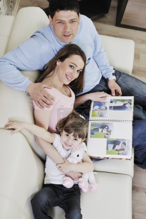Happy family looking photos at home