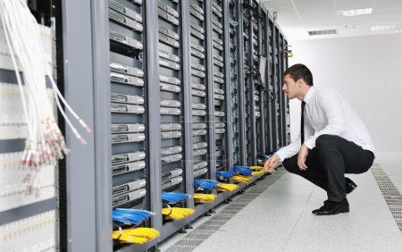 Young handsome business man in black suit practice yoga and relax at network server room while representing stress control concept
