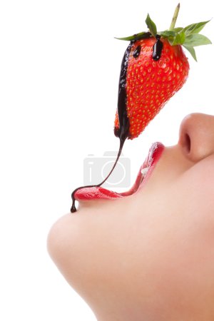 Girl eating strawberry with chocolate sauc