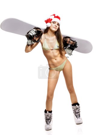 Young athletic snow maiden in santa hat with snowboard