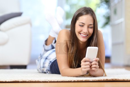 Teenager texting on the mobile phone in the living room