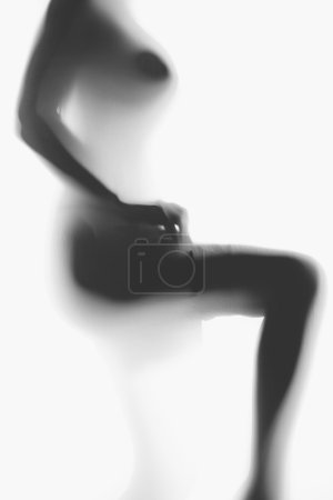 blurred photo of sexy naked woman putting on nylon stockings 