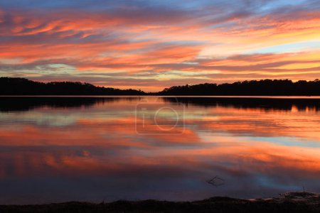 Sunrise and the sky became on fire and mirror reflections in the beautiful Narrabeen Lakes.  Sydney, Australia