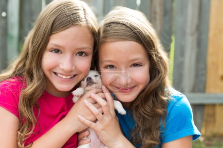 Twin sisters and puppy pet dog chihuahua playing