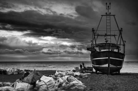 Fishing boat on beach landscape with stormy sky  black and white