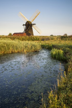 Old drainage windpump windmill in English countryside landscape