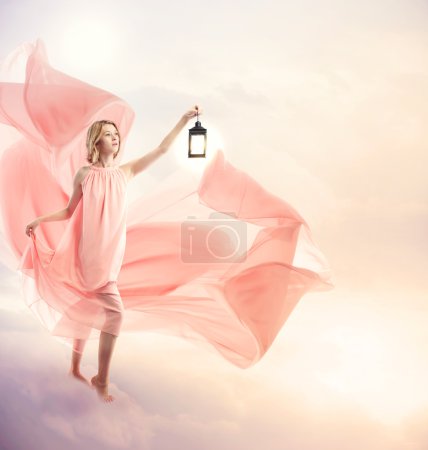 Young woman on fantasy clouds with antique lamp