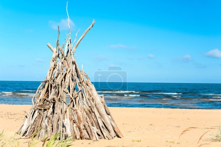 Wigwam Made from wooden branches on the sand of Baltic sea beach
