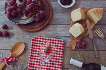 Wine, cheese and grapes on table