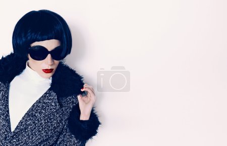 Brunette model in fashionable coat on a white background