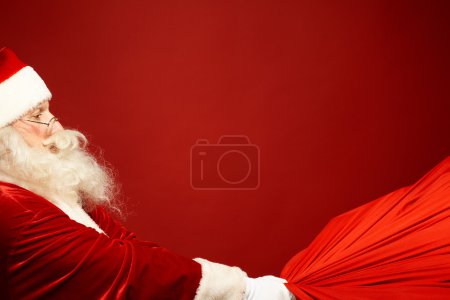 Santa Claus pulling sack with gifts