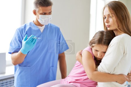 Doctor making injection to little girl