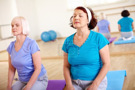 Aged females doing exercise in sport gym
