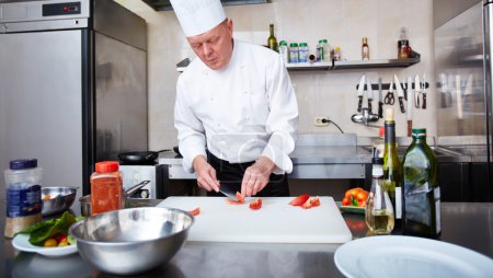 Chef cutting tomatoes