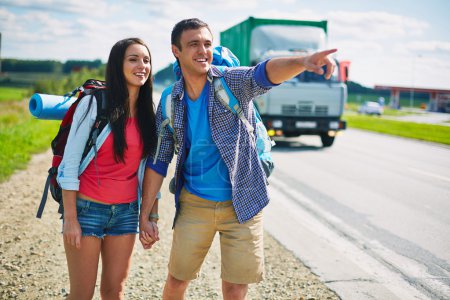 Young hitch-hikers standing by highway