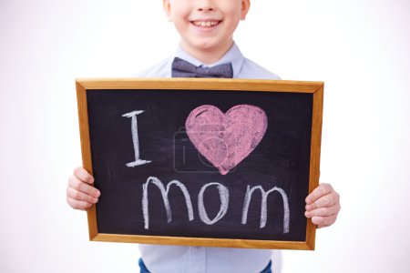Boy holding blackboard with I Love Mom inscription