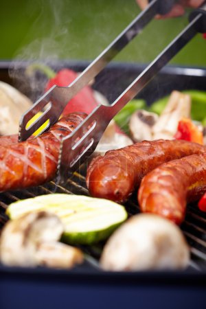 BBQ with fiery sausages on the grill 