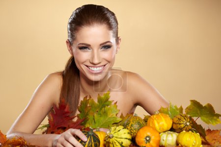 Woman with autumn pumpkin and leaves