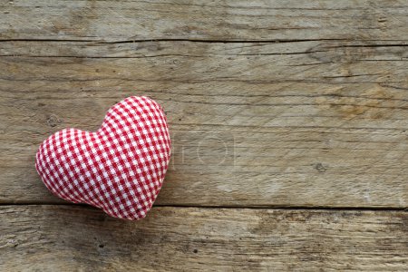 cloth heart with red white pattern on rustic old wood