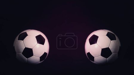 Two classic soccer balls, one in front another, isolated on a black background with copy space for match announcements and advertising. Traditional football playing ball. Tournament rivalry concept